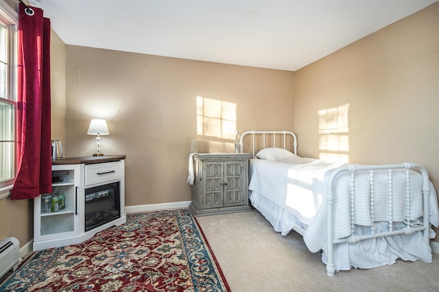 bedroom with light colored carpet and baseboard heating