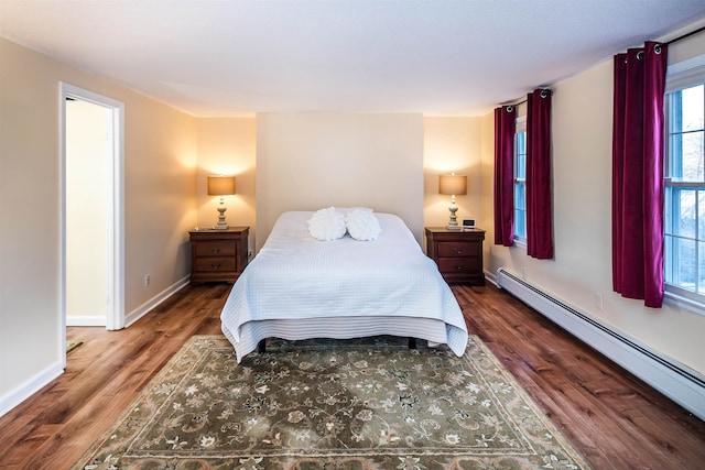 bedroom with baseboard heating and dark wood-type flooring