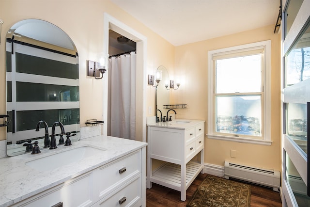 bathroom featuring hardwood / wood-style floors, vanity, and a baseboard heating unit