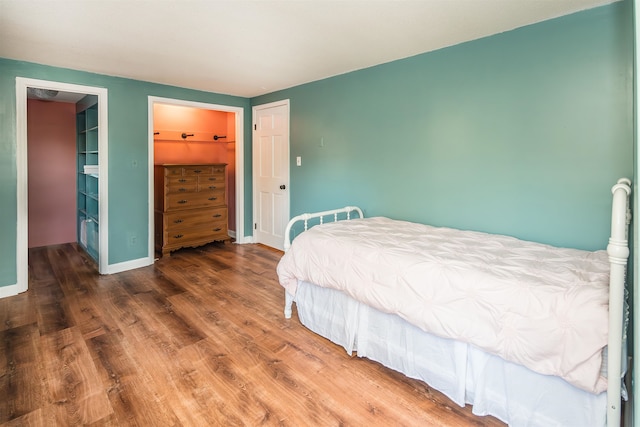 bedroom featuring a closet, hardwood / wood-style floors, and a spacious closet