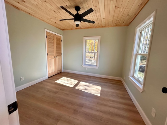 unfurnished bedroom featuring hardwood / wood-style flooring, ceiling fan, wood ceiling, and a closet