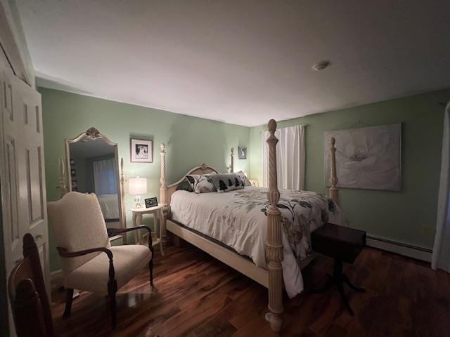 bedroom featuring dark hardwood / wood-style flooring and a baseboard heating unit