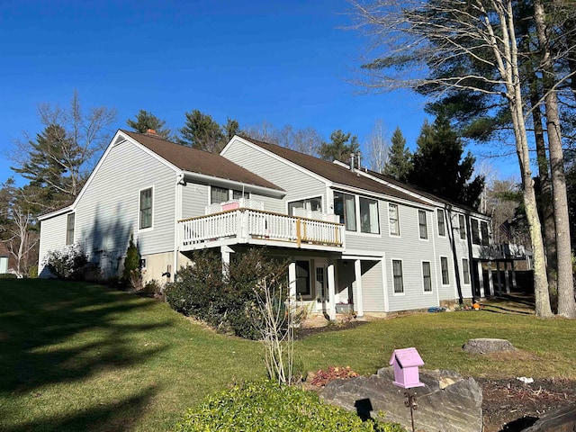 back of property featuring a yard and a wooden deck