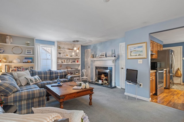 living room featuring a high end fireplace and light hardwood / wood-style flooring