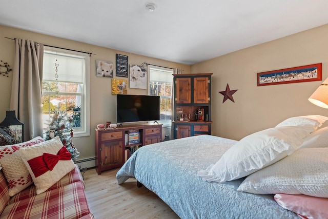 bedroom featuring light wood-type flooring and baseboard heating