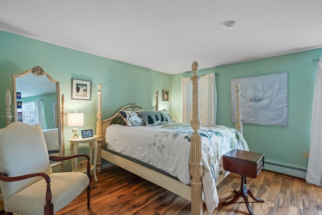 bedroom with dark hardwood / wood-style flooring and a baseboard heating unit