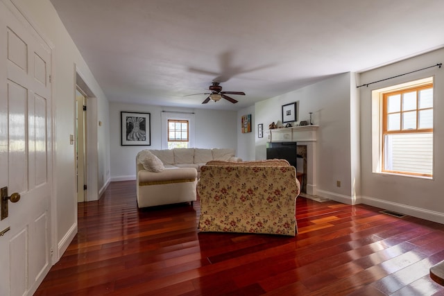 living room featuring ceiling fan and dark hardwood / wood-style flooring