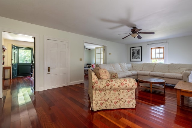 living room with ceiling fan and dark hardwood / wood-style flooring