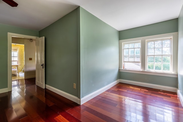 spare room with dark wood-type flooring and a wealth of natural light