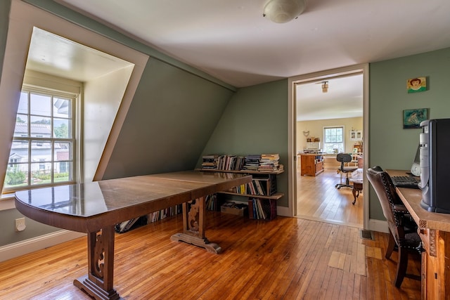 office with light hardwood / wood-style floors and vaulted ceiling