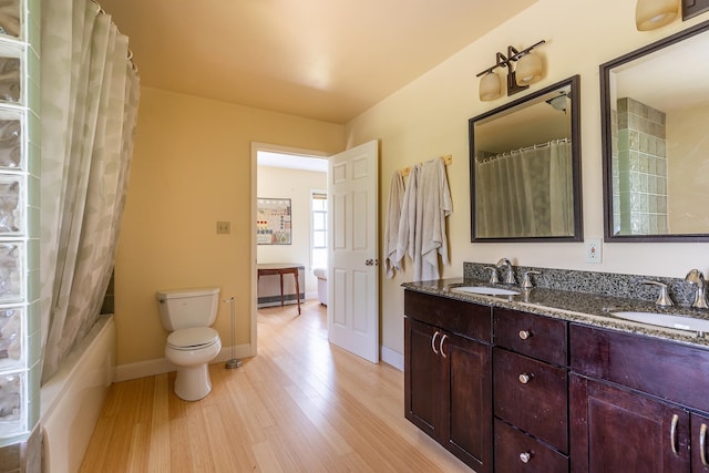 full bathroom featuring shower / bathtub combination with curtain, toilet, vanity, and hardwood / wood-style flooring