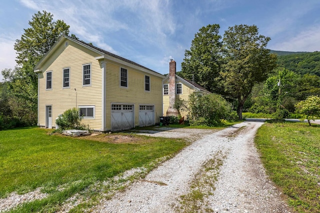 view of property exterior featuring a garage and a lawn