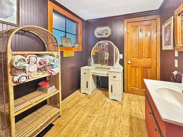 bathroom with vanity, ornamental molding, and hardwood / wood-style flooring