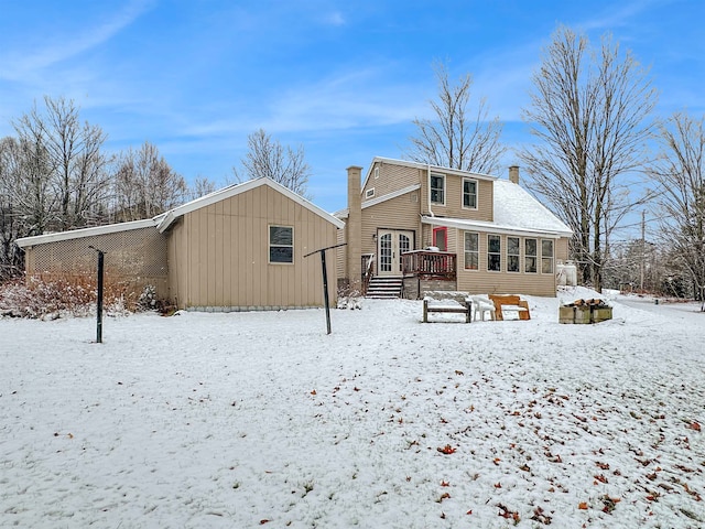 snow covered house with a wooden deck