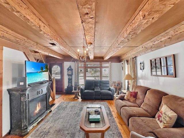 living room featuring beamed ceiling, hardwood / wood-style flooring, and an inviting chandelier