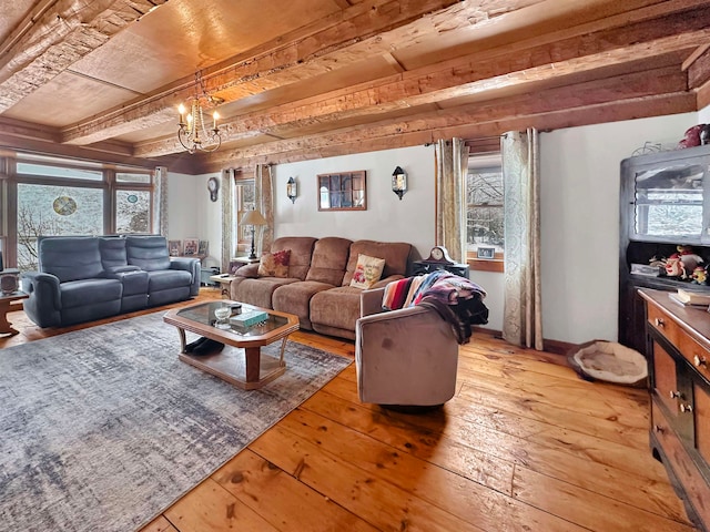 living room featuring wood-type flooring, a notable chandelier, and beam ceiling