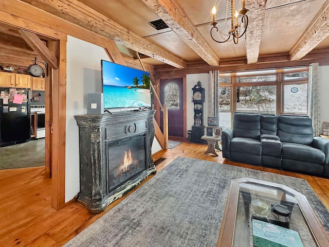 living room featuring beam ceiling, light wood-type flooring, and an inviting chandelier