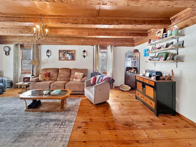 living room featuring beam ceiling, hardwood / wood-style flooring, and an inviting chandelier