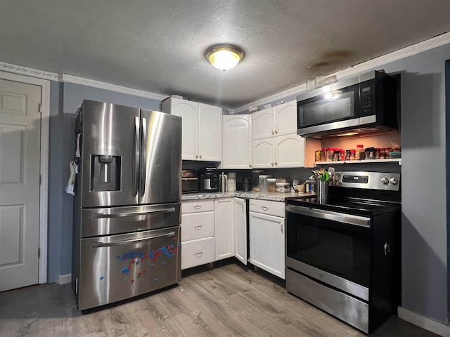 kitchen featuring white cabinets, a textured ceiling, appliances with stainless steel finishes, and light hardwood / wood-style flooring