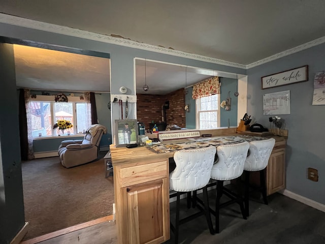 kitchen featuring a healthy amount of sunlight, butcher block counters, crown molding, and dark carpet