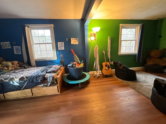 bedroom with wood-type flooring and multiple windows