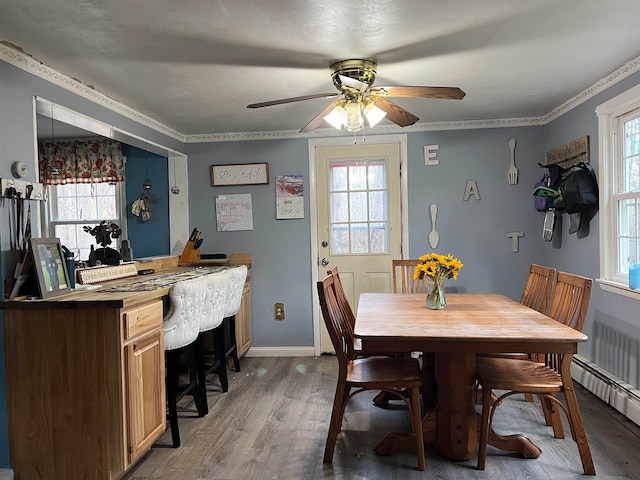 dining room with hardwood / wood-style flooring, ceiling fan, ornamental molding, and a wealth of natural light