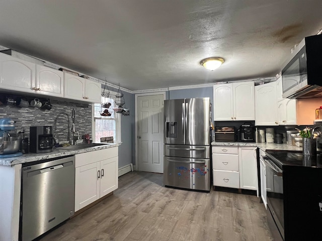 kitchen featuring appliances with stainless steel finishes, crown molding, sink, hardwood / wood-style flooring, and white cabinets