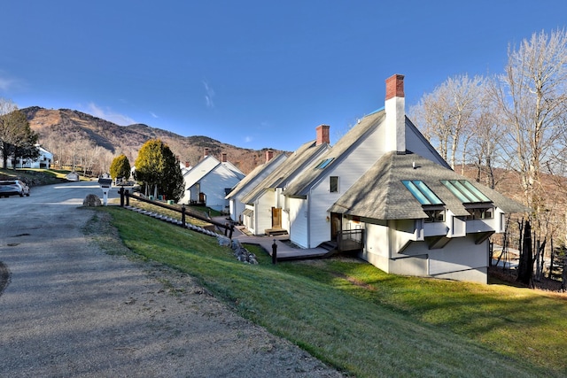 view of home's exterior with a lawn and a mountain view