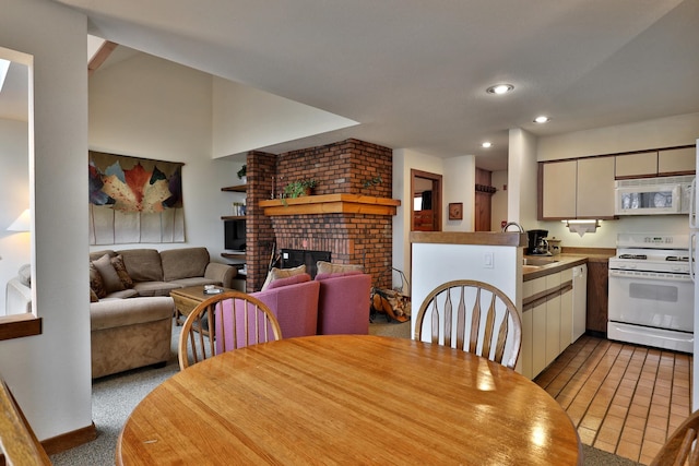 carpeted dining room featuring a fireplace and sink