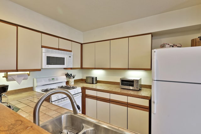 kitchen featuring white appliances and sink