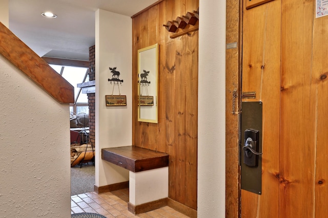 hallway featuring wooden walls