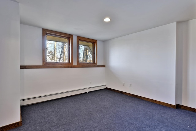 carpeted empty room with a baseboard heating unit