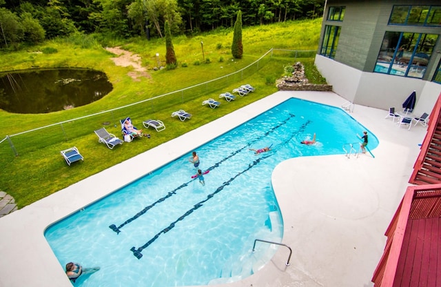 view of swimming pool with a lawn