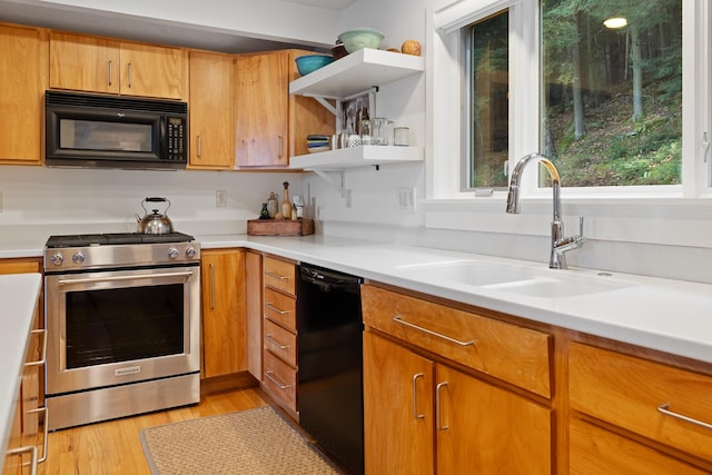 kitchen featuring sink, plenty of natural light, black appliances, and light hardwood / wood-style floors