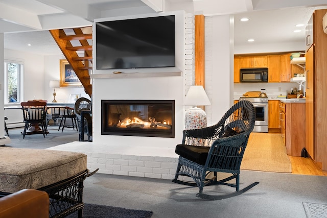 living room featuring beam ceiling, light hardwood / wood-style flooring, and a baseboard heating unit