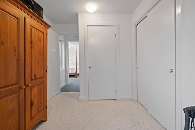 hall with a textured ceiling