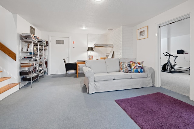 carpeted living room featuring brick wall, a textured ceiling, and a baseboard heating unit