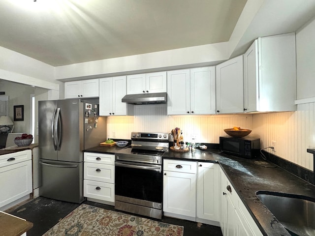 kitchen featuring dark stone counters, sink, white cabinets, and stainless steel appliances