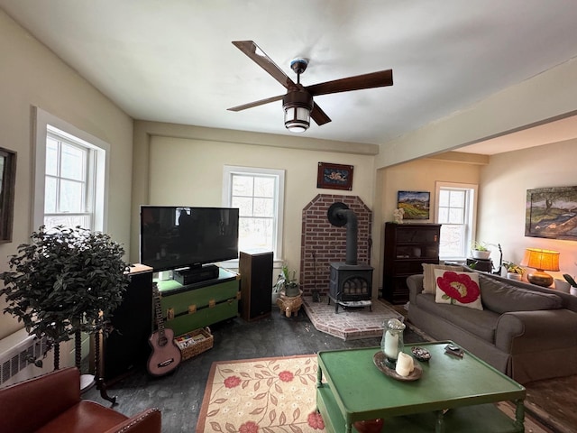 living room with a wood stove and ceiling fan