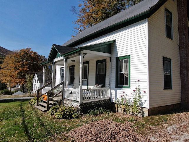 view of front of property featuring covered porch and a front lawn