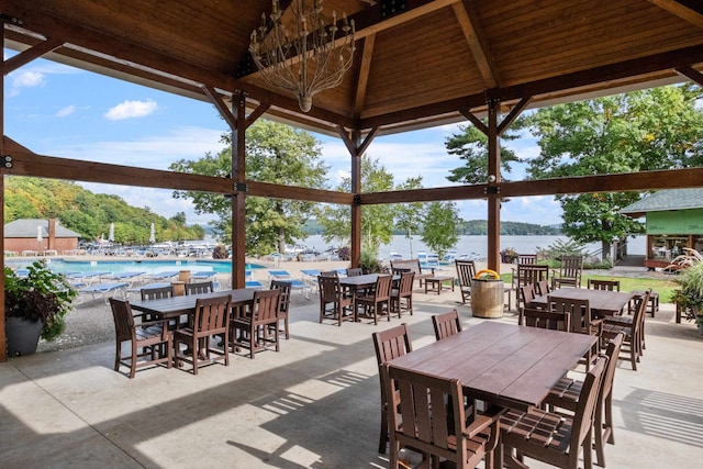 view of patio / terrace with a gazebo, a water view, and a community pool