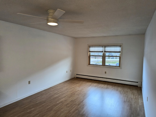 empty room featuring ceiling fan, wood-type flooring, a textured ceiling, and a baseboard heating unit