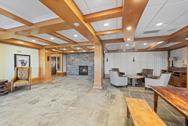 interior space featuring beam ceiling, a stone fireplace, and coffered ceiling