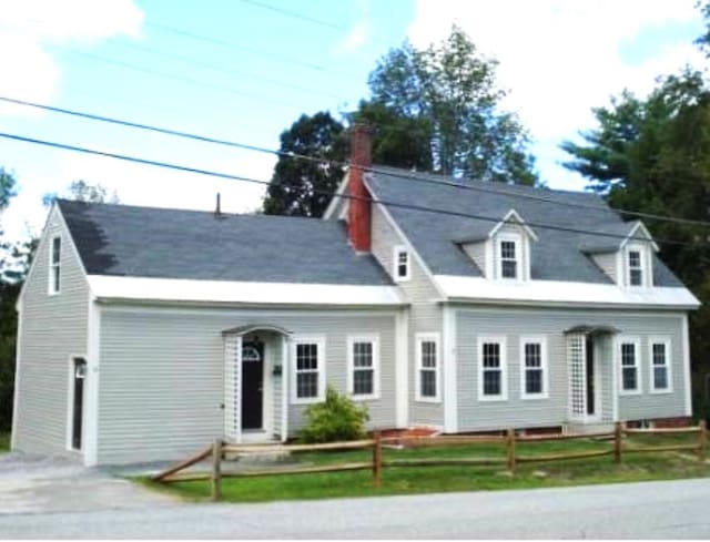 new england style home with a front lawn