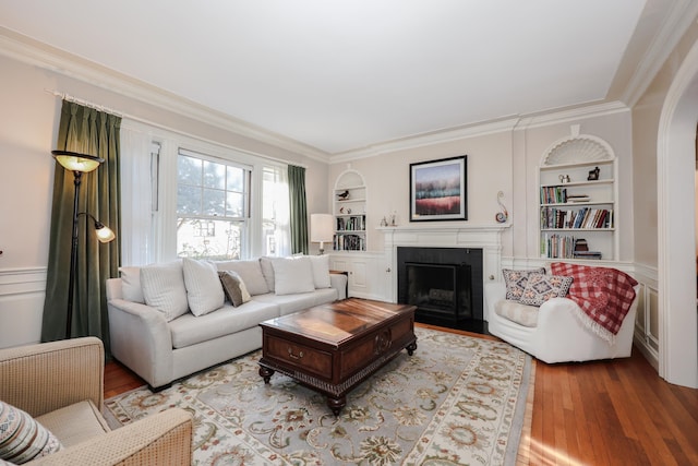 living room with hardwood / wood-style flooring, ornamental molding, and built in features