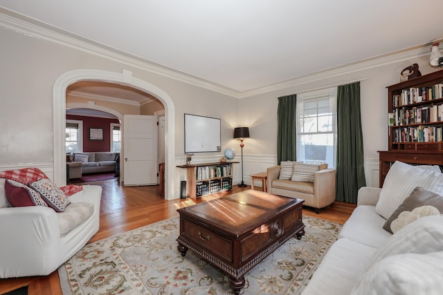 living room with crown molding, light hardwood / wood-style flooring, and a wealth of natural light