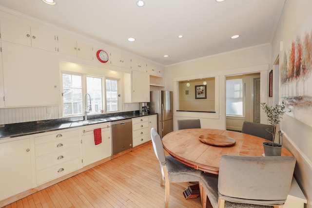 kitchen with sink, crown molding, stainless steel appliances, and a healthy amount of sunlight