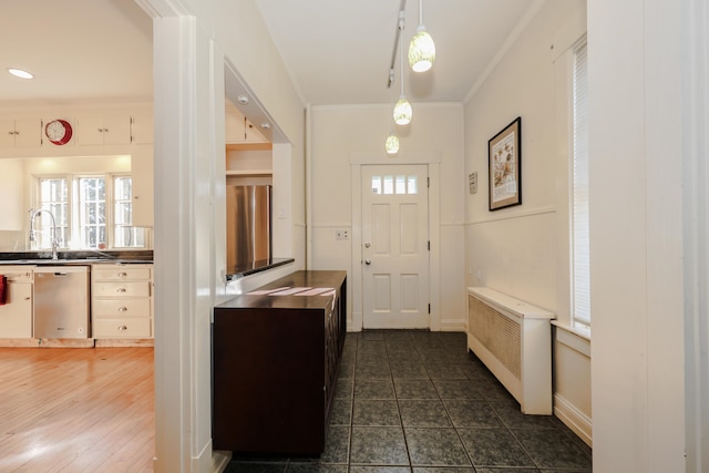 entryway with sink, ornamental molding, and radiator