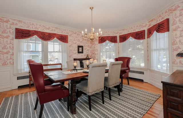 dining space featuring a wealth of natural light, radiator heating unit, and a notable chandelier