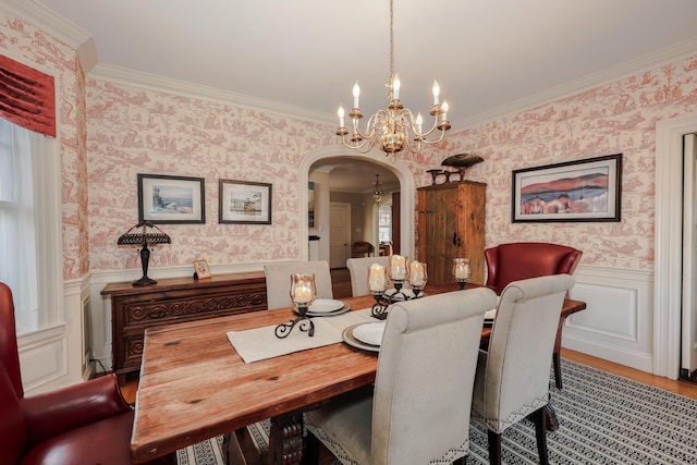 dining room with crown molding, light wood-type flooring, and a chandelier